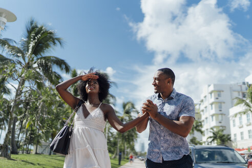 USA, Florida, Miami Beach, happy young couple walking down the road together - BOYF00779