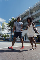 USA, Florida, Miami Beach, glückliches junges Paar beim Überqueren der Straße - BOYF00800