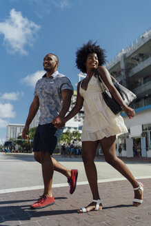 USA, Florida, Miami Beach, glückliches junges Paar beim Überqueren der Straße - BOYF00801