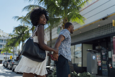 USA, Florida, Miami Beach, glückliches junges Paar beim Überqueren der Straße - BOYF00829