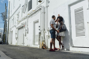 Smiling affectionate young couple standing at building - BOYF00832