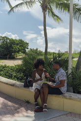 USA, Florida, Miami Beach, young couple with salad and cell phone in a park - BOYF00855