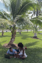 USA, Florida, Miami Beach, junges Paar mit Tablet und Laptop auf Rasen in einem Park - BOYF00867