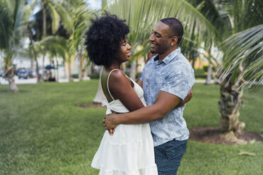 USA, Florida, Miami Beach, glückliches junges Paar umarmt sich in einem Park im Sommer - BOYF00885