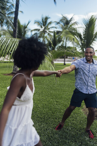 USA, Florida, Miami Beach, glückliches junges Paar tanzt in einem Park im Sommer, lizenzfreies Stockfoto