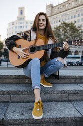 Red-haired woman playing the guitar in the city - JRFF01920