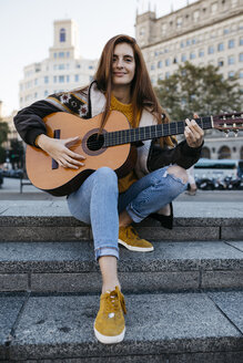 Rothaarige Frau spielt Gitarre in der Stadt - JRFF01920