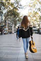Rothaariges Mädchen mit einer Gitarre in der Stadt, Rückansicht - JRFF01922