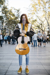 Red-haired woman holding a guitar in the city - JRFF01924