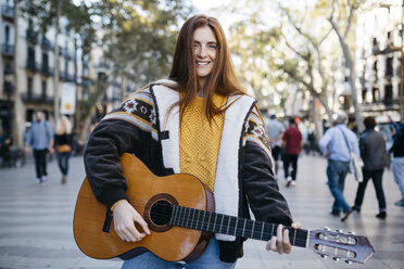 Red-haired woman playing the guitar in the city - JRFF01925