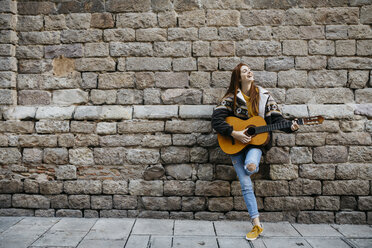 Red-haired woman playing the guitar in the city - JRFF01932