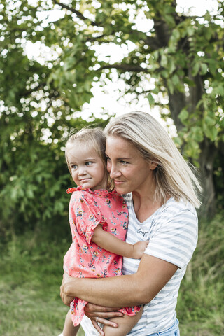 Lächelnde Mutter mit Tochter in der Natur, lizenzfreies Stockfoto