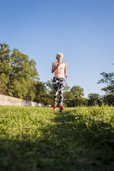 Senior woman running on rural meadow - DIGF05449