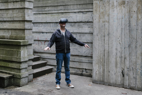 Ein Mann mittleren Alters trägt ein Virtual-Reality-Headset. - MINF09568