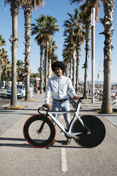 Ein erwachsener Mann steht auf der Straße und zeigt sein Fixie-Fahrrad - JRFF01952