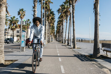 Mittlerer erwachsener Mann fährt Fahrrad in der Stadt, in der Nähe des Strandes - JRFF01954