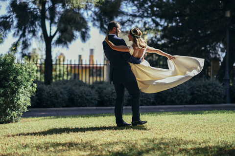Brautpaar genießt seinen Hochzeitstag in einem Park, lizenzfreies Stockfoto
