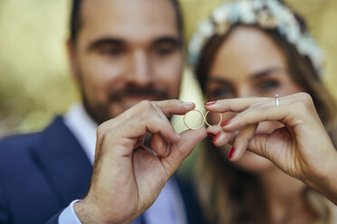 Happy bridal couple showing their wedding rings, close-up - JSMF00569