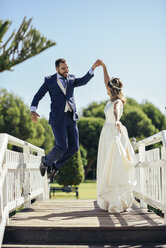 Bridal couple enjoying their wedding day in a park - JSMF00572