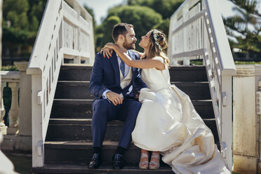 Brautpaar auf einer Treppe in einem Park sitzend - JSMF00575