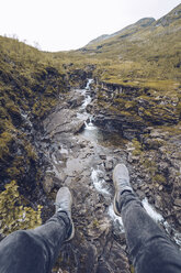 Legs of young man, sitting st a brook - RSGF00091