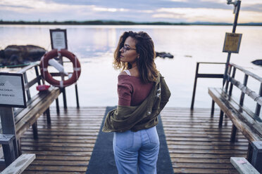 Pretty young woman posing on a pier at Lake Inari, Finland - RSGF00109