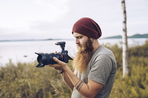 Junge Fotografin beim Fotografieren in der Natur, lizenzfreies Stockfoto