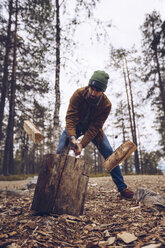 Young man chopping woog in the forest - RSGF00118