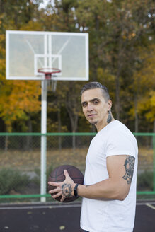 Porträt eines Mannes mit Basketball im Herbst - VGF00101