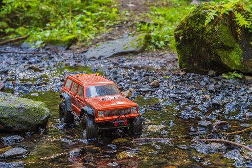 Germany, remote control car driving through brook - FRF00757