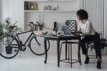 Mid adult woman working in her home office, using laptop - BOYF00892