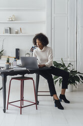 Mid adult woman working in her home office, using laptop - BOYF00893