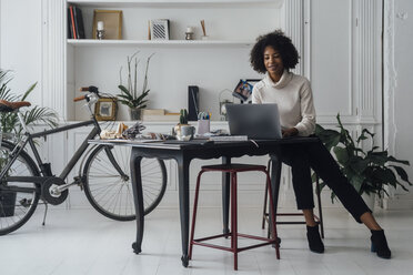 Mid adult woman working in her home office, using laptop - BOYF00895