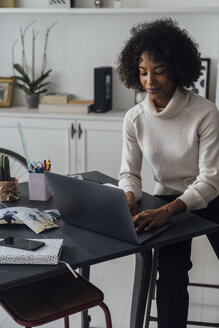 Mittlere erwachsene Frau, die in ihrem Heimbüro arbeitet und einen Laptop benutzt - BOYF00896
