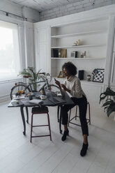 Mid adult woman working in her home office, using laptop - BOYF00897