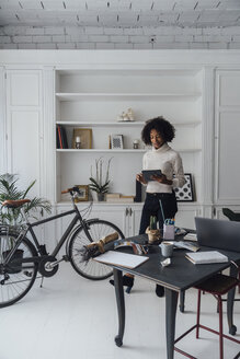 Mittlere erwachsene Freiberuflerin in ihrem Büro zu Hause, mit digitalem Tablet - BOYF00907