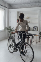 Mid adult woman leaving her home office, pushing bicycle - BOYF00942
