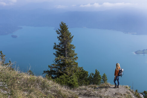 Junge Frau beim Wandern in den bayerischen Bergen, Blick auf den Walchensee - TCF05913