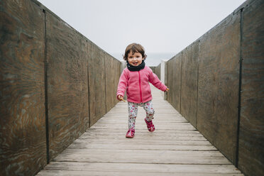 Baby girl walking on a wooden walkway - GEMF02505