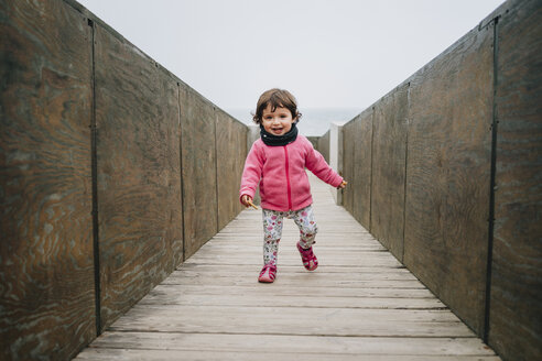 Ein kleines Mädchen läuft auf einem Holzsteg - GEMF02505