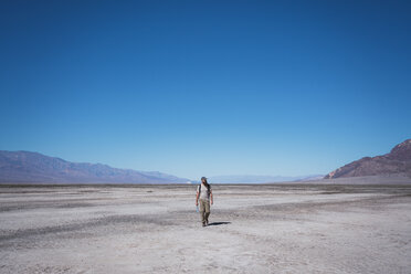 USA, Kalifornien, Death Valley, Mann läuft in der Wüste - KKAF02958