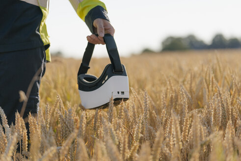 Nahaufnahme eines Mannes in Arbeitsschutzkleidung und VR-Brille in einem Feld - GUSF01310