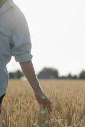 Close-up of man in a field touching ears - GUSF01314