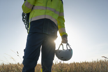 Close-up of technician in a field with climbing equipment - GUSF01334