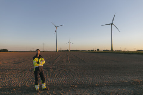 Engineer standing in a field at a wind farm stock photo