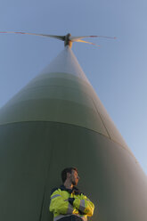 Tiefblick eines Ingenieurs, der an einer Windkraftanlage steht - GUSF01382