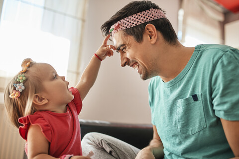 Father and little girl having fun together at home stock photo