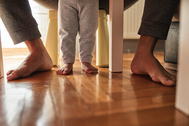 Die Füße des Vaters und der kleinen Tochter barfuß auf dem Parkett - ZEDF01754