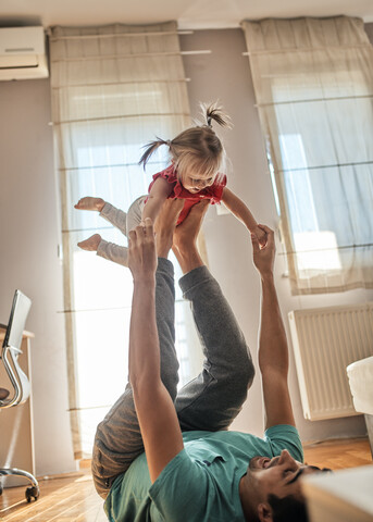 Father playing with his little daughter at home stock photo