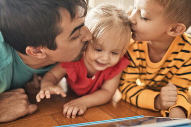 Father and brother kissing happy little girl - ZEDF01770